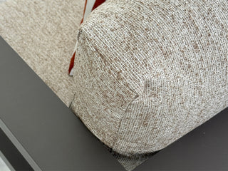 Close-up of a textured woven fabric outdoor cushion in a light beige and brown tone.
