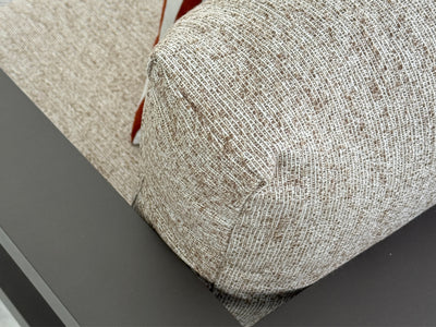 Close-up of a textured woven fabric outdoor cushion in a light beige and brown tone.